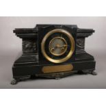 A large black Slate mantle clock. Comprising of a black and gilt dial, Lion feet and a brass