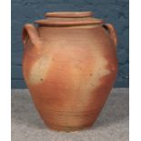 A twin handled Terracotta Ali-baba style lidded pot. H:40cm. Condition fair. The lip on the inside