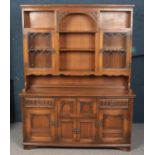 An Old Charm carved oak dresser. With lead glazed top, and secretaire, drawer and cupboard base.