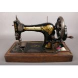 A wooden cased Singer sewing machine. Model no V1212329.
