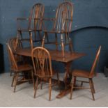 An Old Charm oak refectory table and set of six wheel back chairs.
