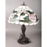 A large Tiffany style table lamp. With floral shade and metal base.