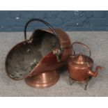A copper coal scuttle along with a copper teapot on brass stand.