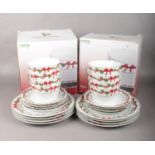 Two boxed sets of Christmas crockery. Comprising of a twelve piece dinner set to include plates,