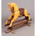 A carved and painted wooden rocking horse, handmade by Tom Thackray, Wadworth. With saddle. Height