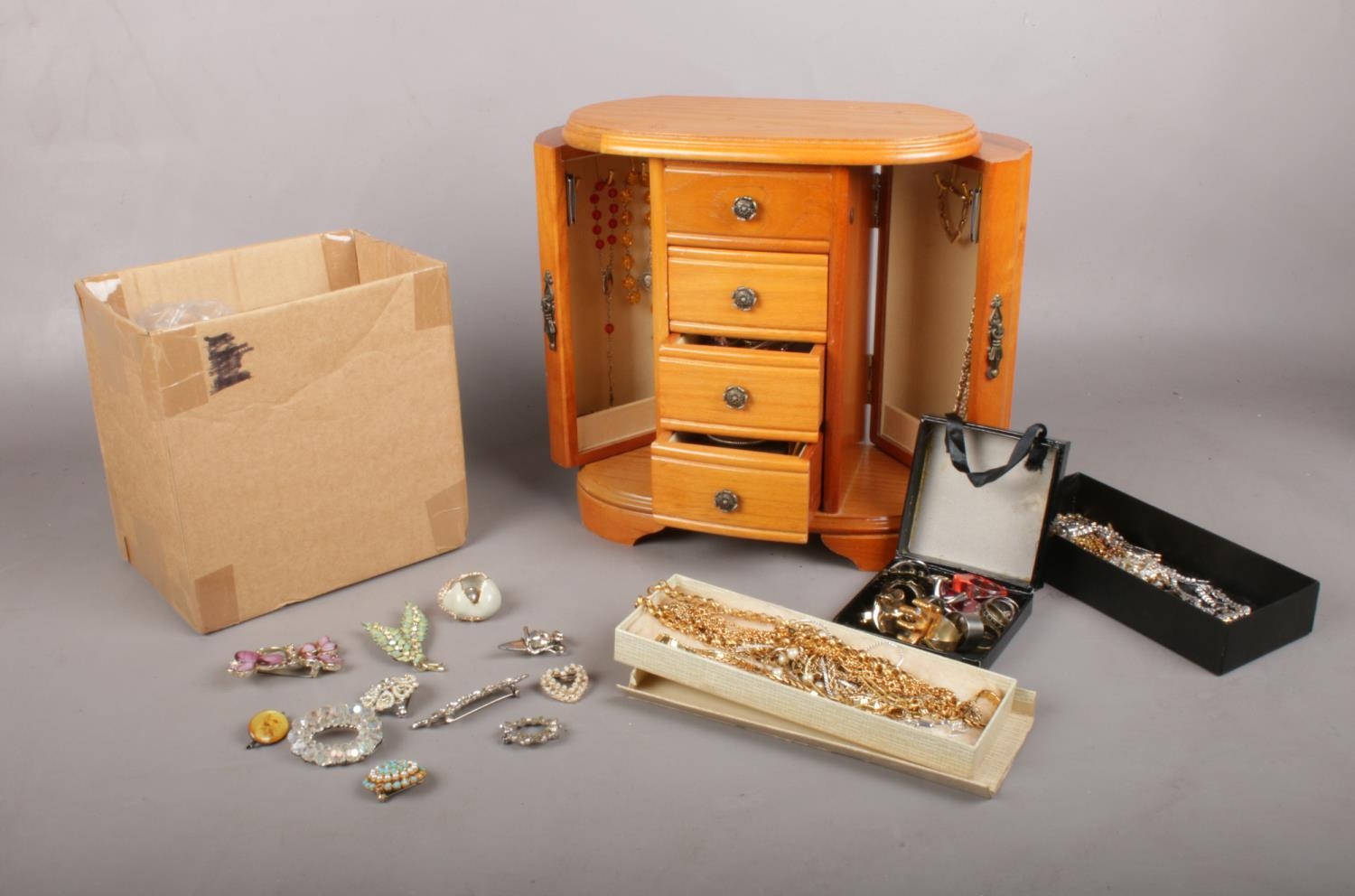 A group of costume jewellery & wooden jewellery box. Brooches, beads, necklaces etc