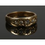 An 18ct gold five stone diamond ring. Size S. 7.62g. Centre stone with slight chip.