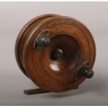 A vintage wooden fly fishing reel.