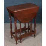 An Oak oval top gate leg table raised on turned supports. H: 76cm, W:60cm, L:90cm fully extended.