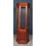 A stained mahogany hexagonal display cabinet.