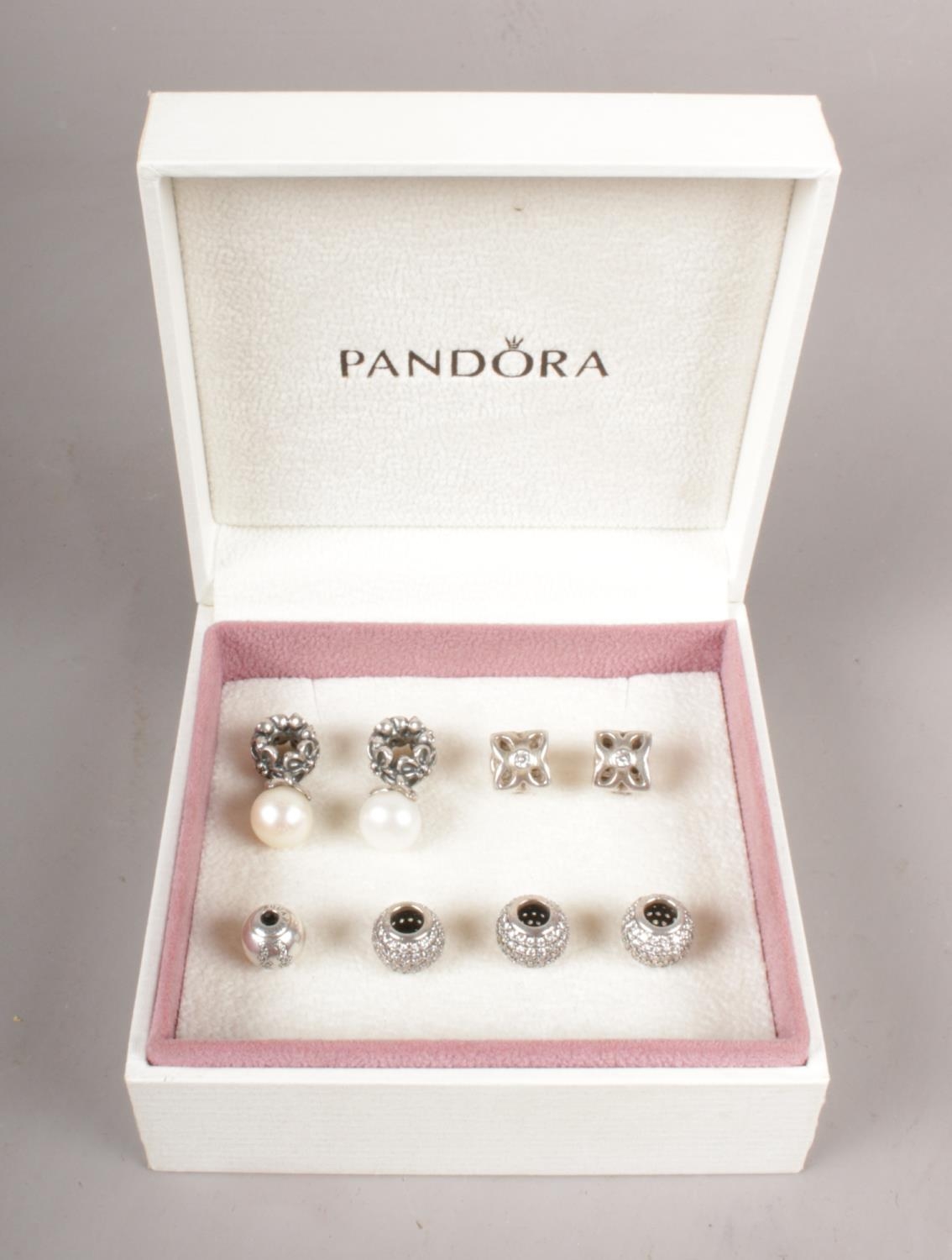 Eight Sterling Silver (925) discontinued Pandora charms in original box.
