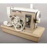 A cased New Home electric sewing machine.