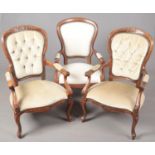 Three carved mahogany deep buttoned arm chairs.