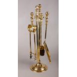 A brass fireside companion set. To include shovel, brush, tongs and stoker. H: 44cm.