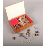 A jewellery box with contents of costume jewellery. Including cross pendants, paste set examples,