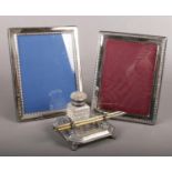 Two silver plated photo frames, together with a writing desk set. Comprising of an ink well and