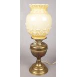 A brass and glass oil lamp converted to electric. With cream coloured shade with floral decoration.