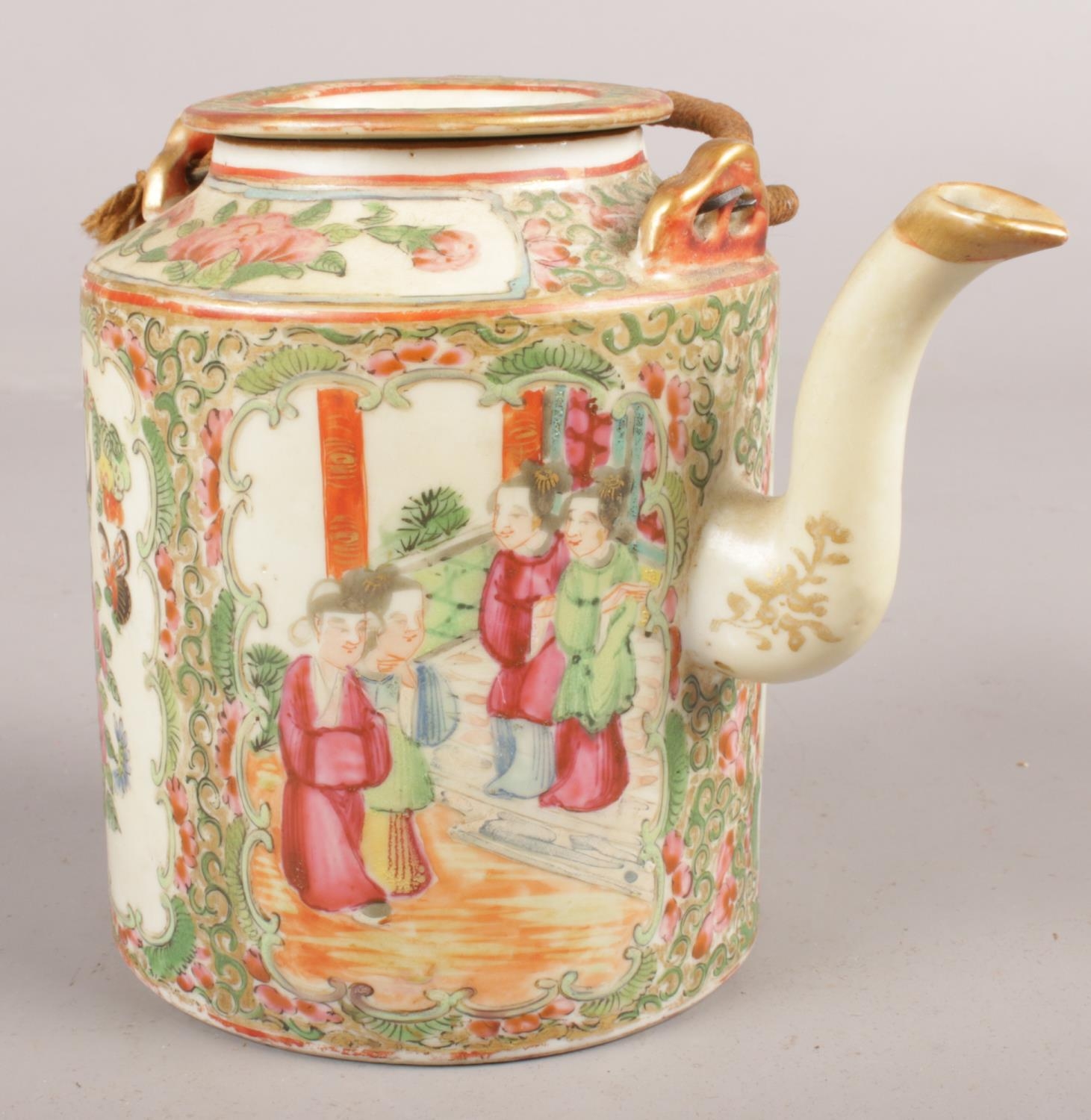 A Cantonese ceramic teapot decorated with figures and flowers.