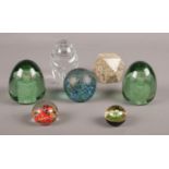 A group of mostly glass paper weights. various sizes & styles.