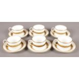 Six Coalport Cups and Saucers in the 'Citation' pattern, with floral decoration on a Gilt