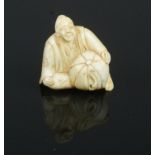 A carved ivory netsuke, in the form of a sitting gentleman.