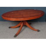 A Yewwood Oval Coffee Table, On Brass Mounted Casters.