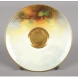 A Royal Worcester porcelain saucer with hand painted decoration, signed A Shuck. 10cm diameter.