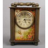 A miniature brass carriage clock. With erotic glass panels. 7cm tall. Missing winder.