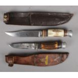 Two small sheathed hunting knives. Includes R Cooper and Atlanta.