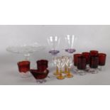 A group of assorted glassware. cranberry glass shot glasses, cut crystal cake stand etc.
