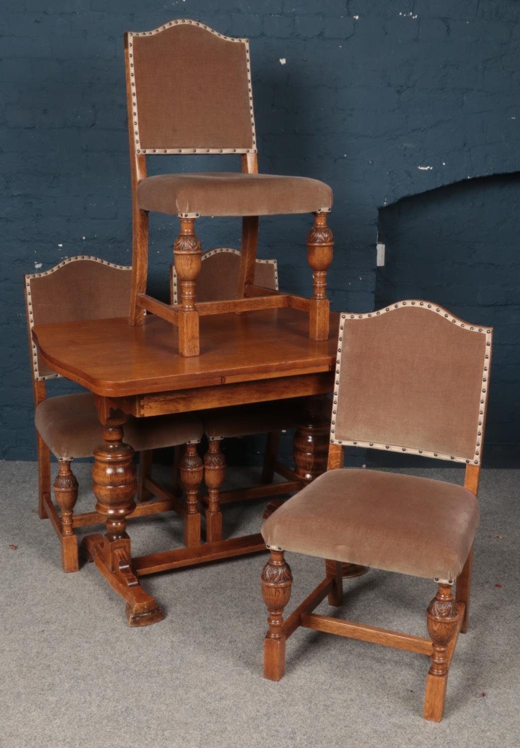 An Oak Draw-leaf Extending Table with Four Oak and Fabric Studded Chairs.