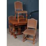 An Oak Draw-leaf Extending Table with Four Oak and Fabric Studded Chairs.