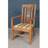 An Art & Crafts style Oak Elbow chair. H: 96cm, W: 58cm.