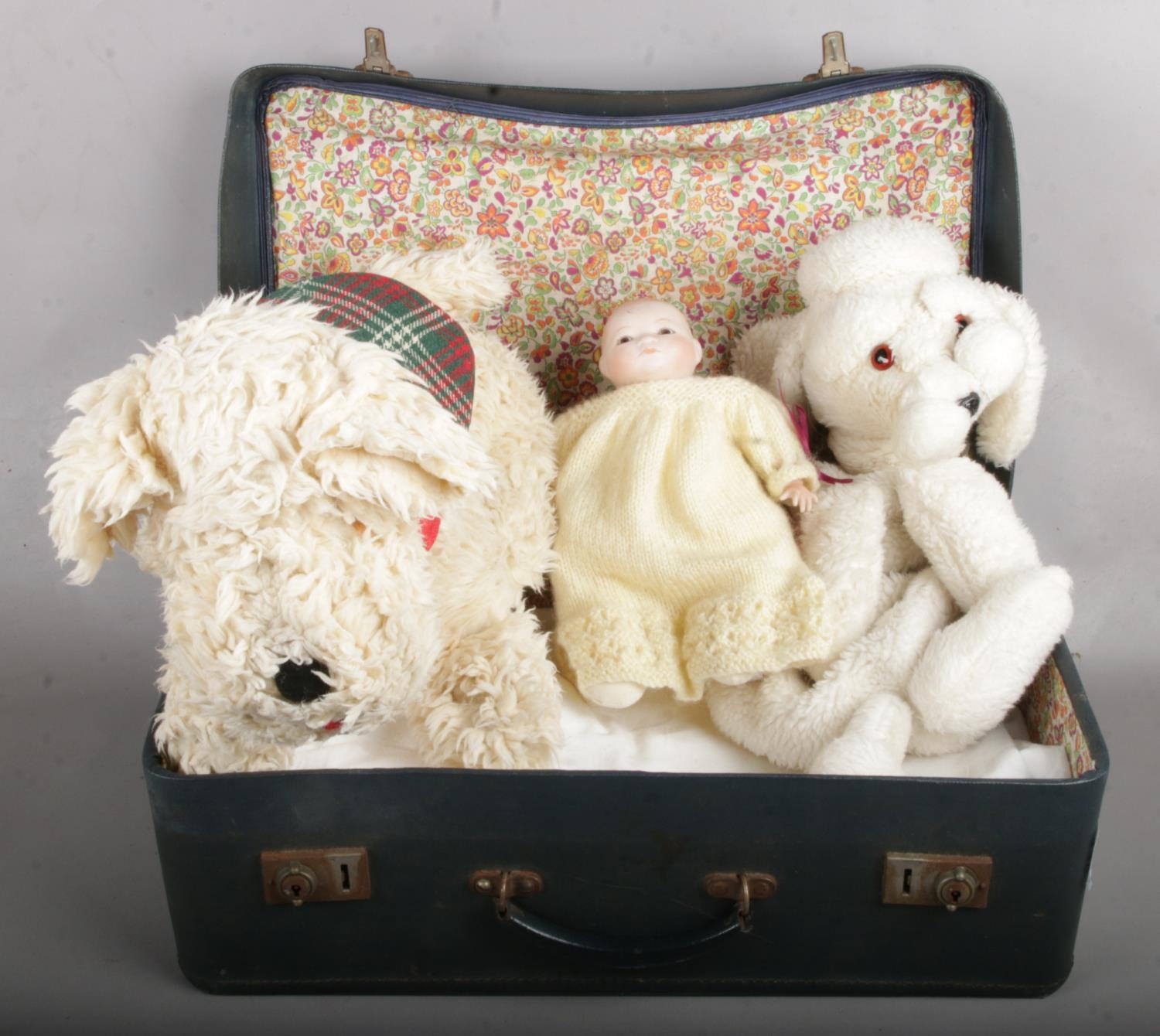 A Navy Blue Suitcase Containing Mostly Linen, along with Soft Toys and Dolls.