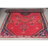 A red ground wool Aztec design rug. L:290cm, W: 140cm.
