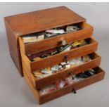 A Four Drawer Wooden Cabinet Containing Clock Parts, Spares and Repairs.