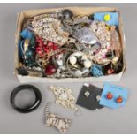 A box of costume jewellery. Including white paste stone set tiger brooch, necklaces, clip on