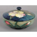 A Moorcroft lidded powder bowl, decorated in the Fresia pattern on a blue/green ground. H: 10cm,