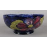 A Walter Moorcroft "Hibiscus" pattern bowl on a deep blue ground. H: 9cm, D: 20cm. Signed to the