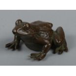 A small Japanese bronze figure of a frog. Marked to base.