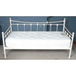 A white painted metal painted day bed with shell mounted decoration.