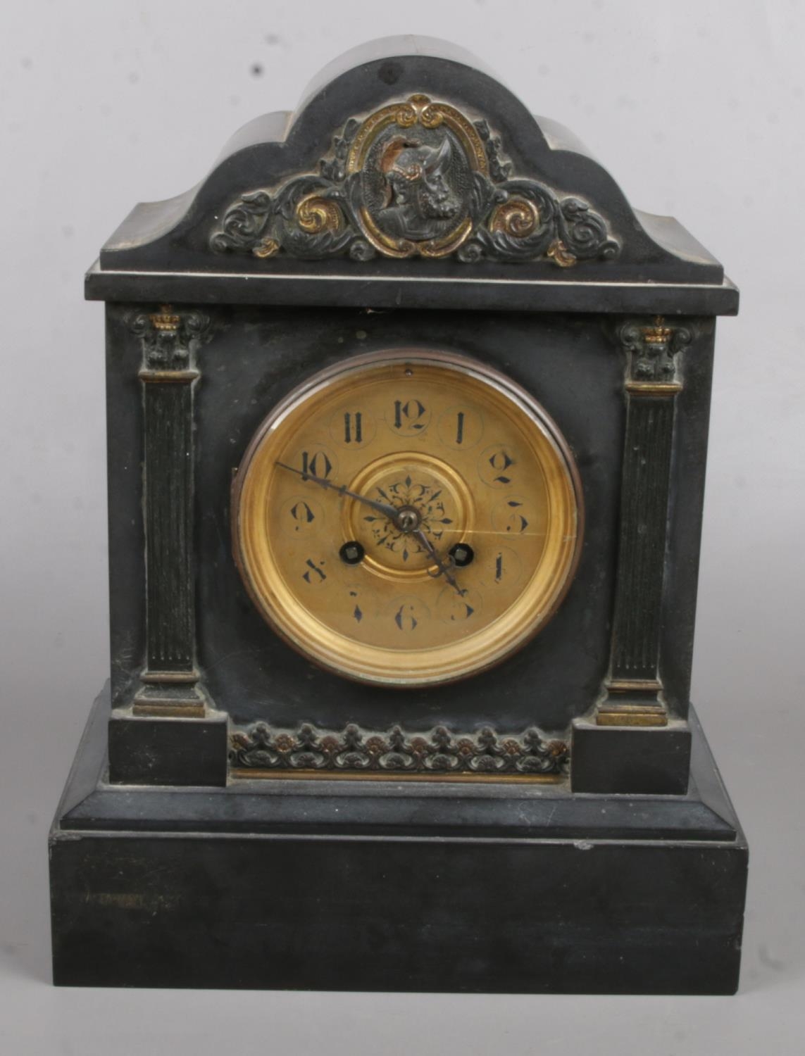 A Black Slate Marble Clock with Gold Cartouche Decoration to the Top. Crack in the Glass on the
