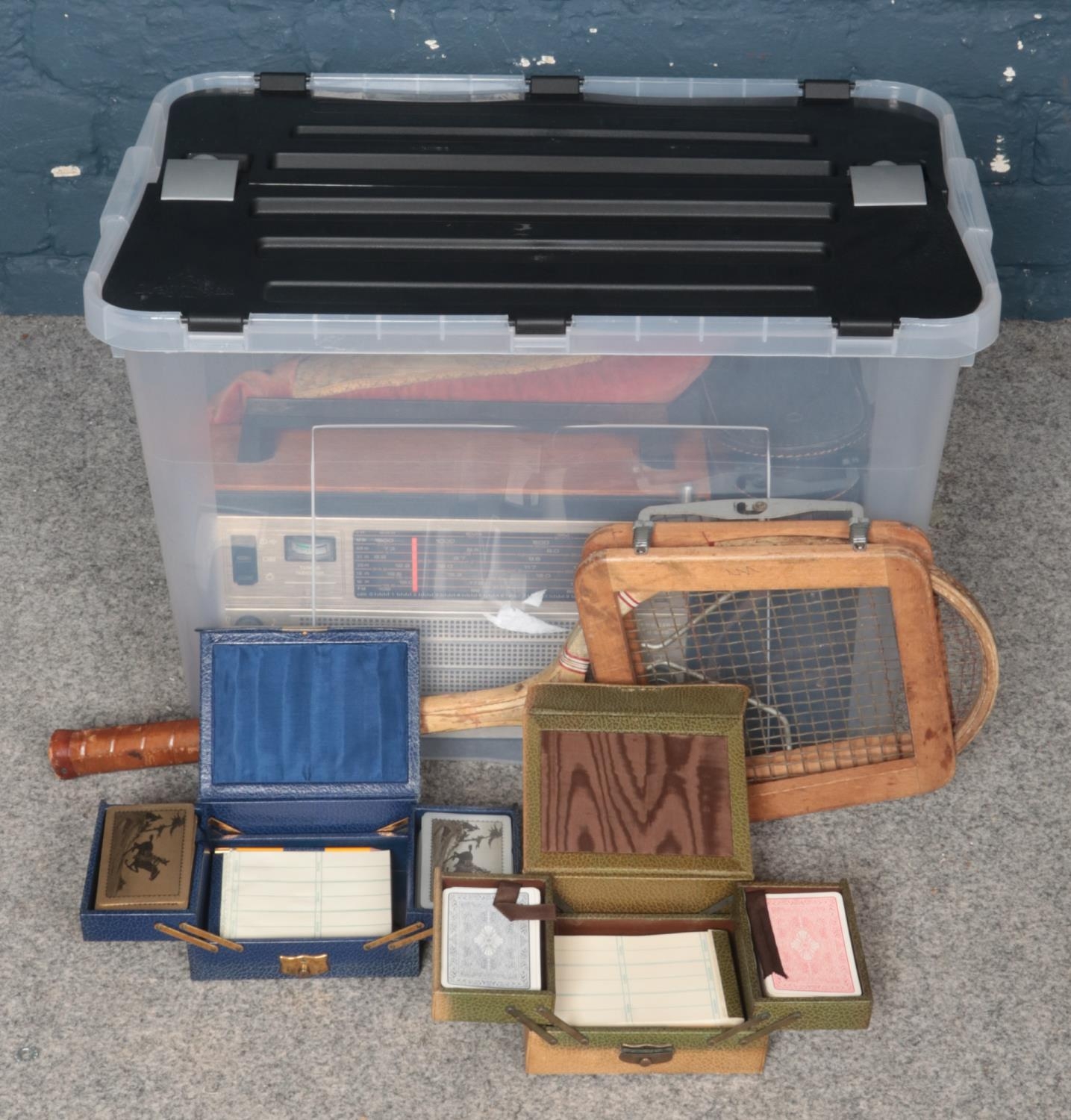 A Box of Assorted Items. To include Two Unopened Bridge Sets, a Battery Powered Radio and a