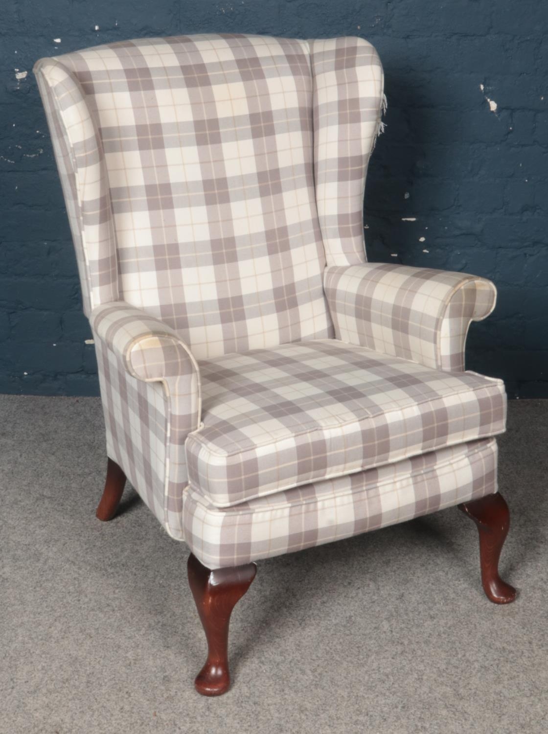 A Reupholstered Wingback Armchair. Condition Fair, tear on Right Wing.