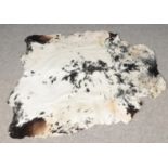 A black & white cowhide rug. (140cm x 137cm)