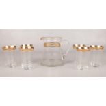 A set of six gilt rimmed water glasses & water jug.