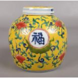 A Chinese yellow ground ginger jar with six marks to the base and Chinese characters around the jar.