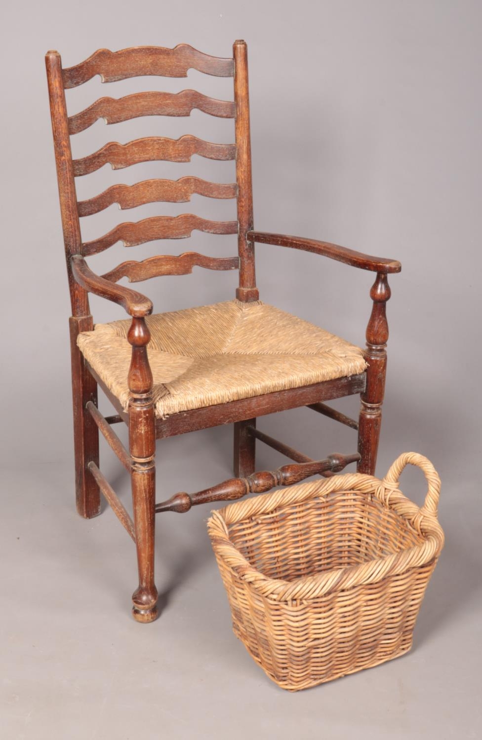 A vintage ladder back wicker chair. (106cm height 56cm width, 47cm depth) To include wicker basket.