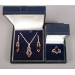 A silver and amber coloured jewellery suite. Includes pendant on chain, earrings and ring.