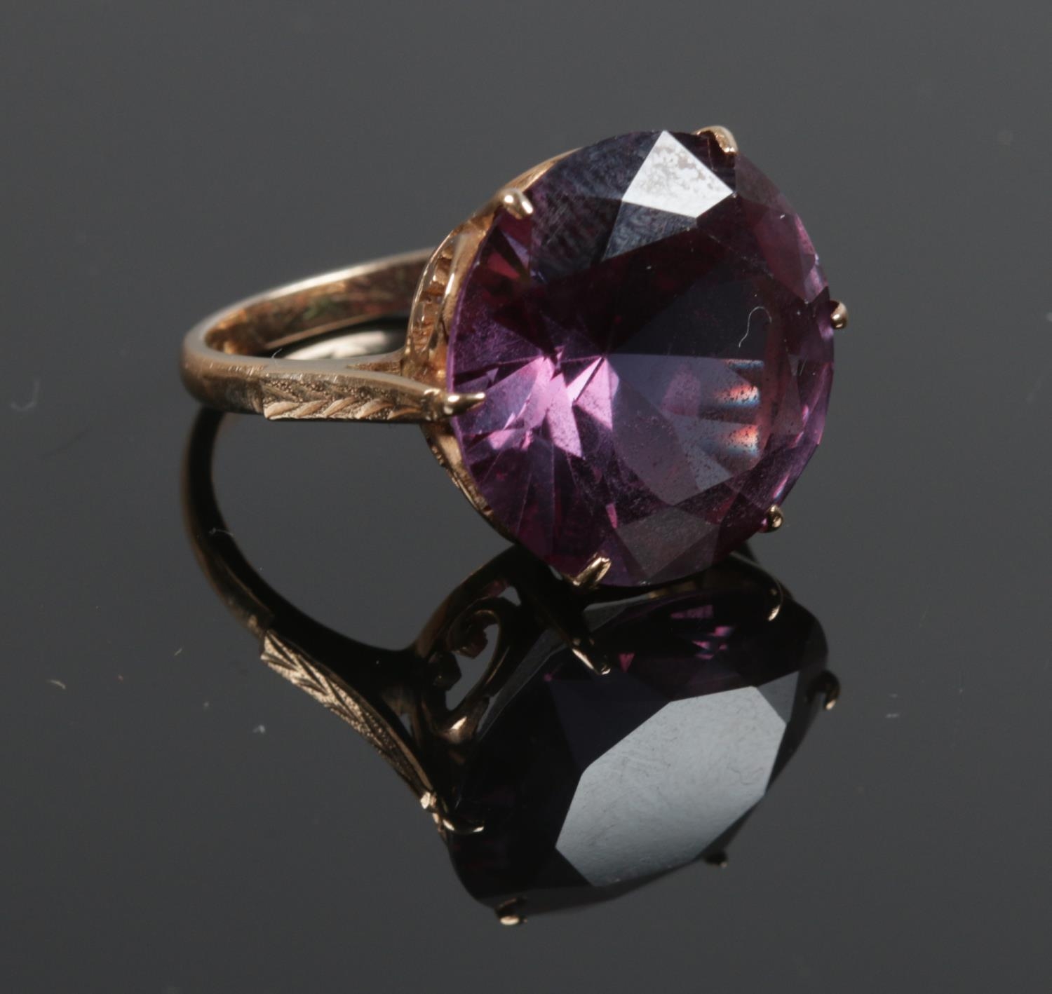 A 14ct gold ring with large purple facetted stone and crown shank. Size O. Gross weight: 8g.